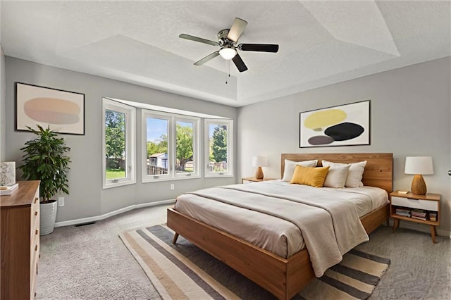 1108 W Pleasant Dr, Raymore, MO 64083 - bedroom featuring light colored carpet, a raised ceiling, a textured ceiling, and ceiling fan