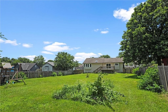 1108 W Pleasant Dr, Raymore, MO 64083 - fenced backyard featuring stairs, a playground, and a deck