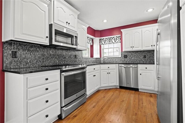 1002 W Howard Pl, Louisburg, KS 66053 - kitchen with appliances with stainless steel finishes, dark countertops, white cabinets, and recessed lighting