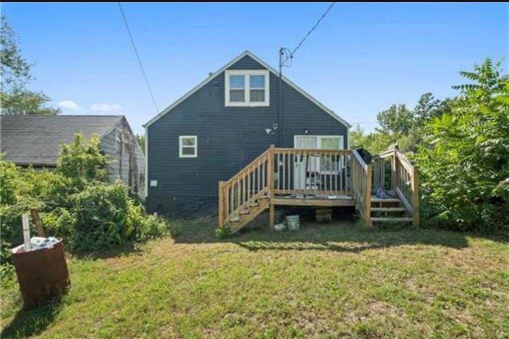 3133 Chelsea Ave, Kansas City, MO 64128 - rear view of property with a lawn, a deck, and stairs