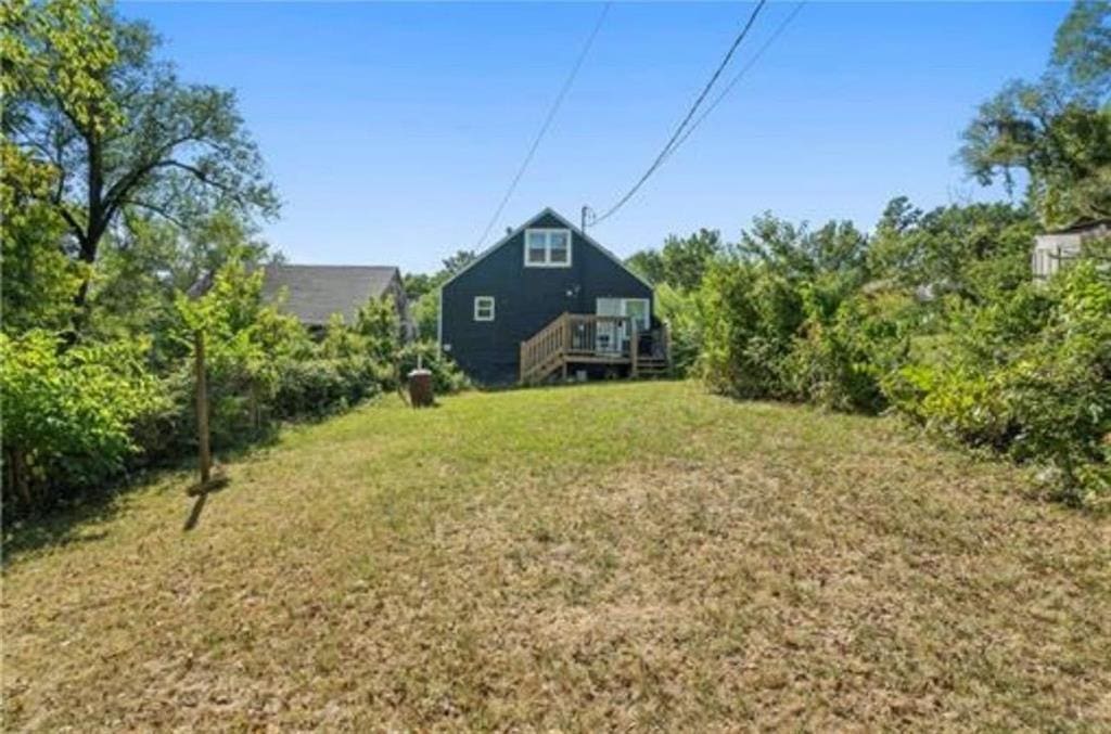 3133 Chelsea Ave, Kansas City, MO 64128 - view of grassy yard with a deck