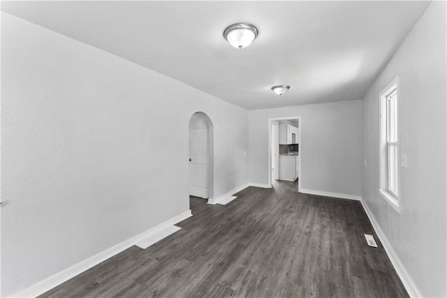 1205 E Parker Ave, Independence, MO 64050 - unfurnished room with arched walkways and dark wood-style flooring