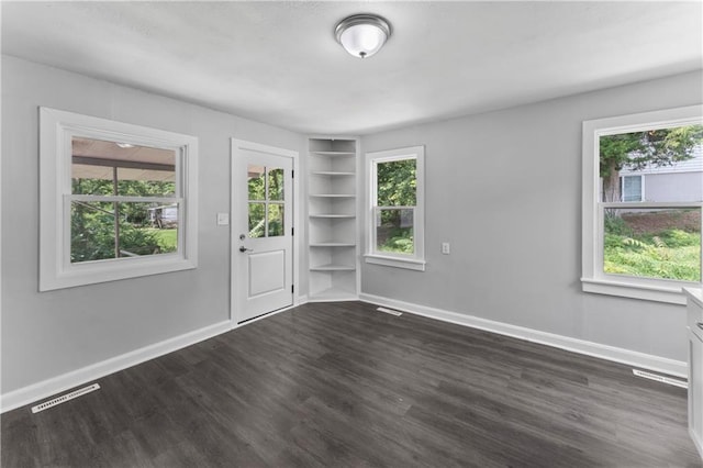 1205 E Parker Ave, Independence, MO 64050 - unfurnished room featuring built in shelves and dark wood-style flooring