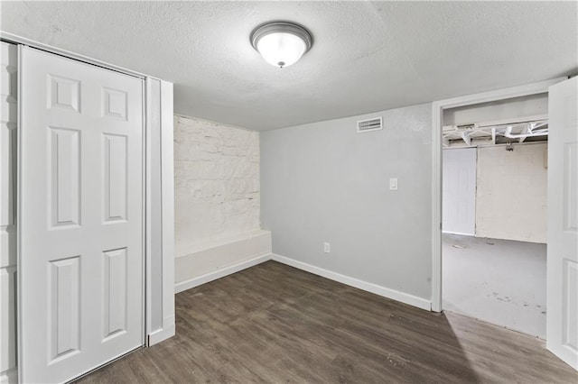 1205 E Parker Ave, Independence, MO 64050 - unfurnished bedroom featuring a textured ceiling, wood finished floors, and a closet