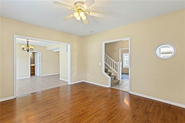 420 S Walnut St, Ottawa, KS 66067 - unfurnished room with a chandelier, wood finished floors, stairway, and a ceiling fan