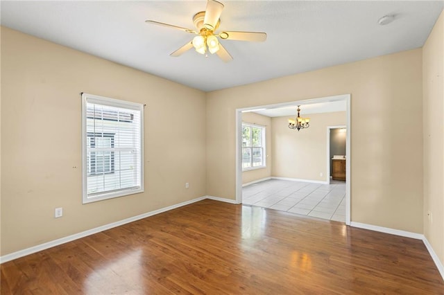 420 S Walnut St, Ottawa, KS 66067 - unfurnished room featuring a chandelier, wood finished floors, a smoke detector, and a ceiling fan