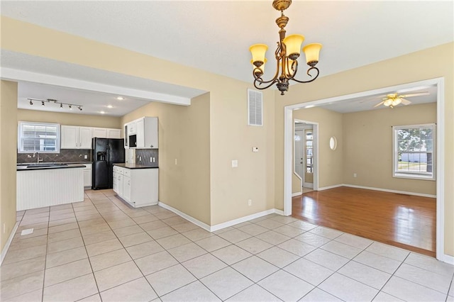420 S Walnut St, Ottawa, KS 66067 - kitchen with black refrigerator with ice dispenser, dark countertops, open floor plan, light tile patterned floors, and decorative backsplash