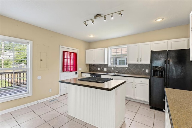 420 S Walnut St, Ottawa, KS 66067 - kitchen featuring black refrigerator with ice dispenser, white cabinetry, electric panel, tasteful backsplash, and healthy amount of natural light