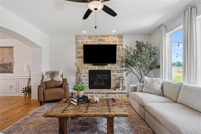 24328 W 58th Ter, Shawnee, KS 66226 - living area featuring wood finished floors, a ceiling fan, a fireplace, arched walkways, and recessed lighting