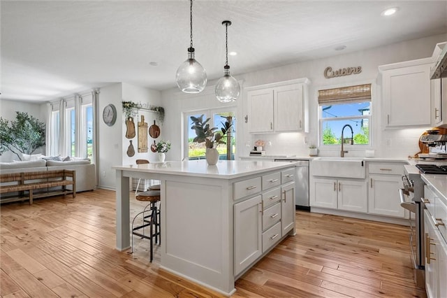 24328 W 58th Ter, Shawnee, KS 66226 - kitchen featuring appliances with stainless steel finishes, open floor plan, a center island, a kitchen breakfast bar, and light countertops