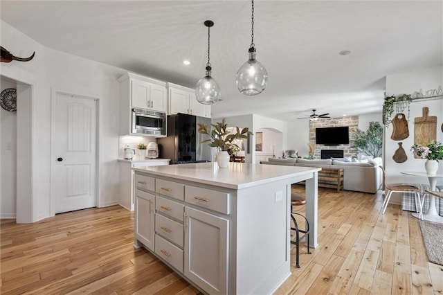 24328 W 58th Ter, Shawnee, KS 66226 - kitchen with stainless steel microwave, a ceiling fan, light wood finished floors, refrigerator, and a breakfast bar area