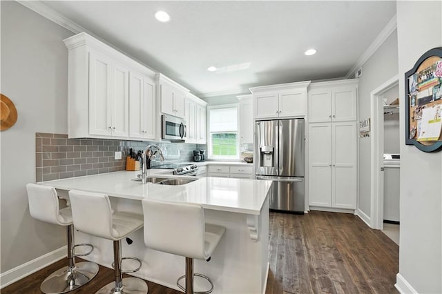 704 E 110th Ter, Kansas City, MO 64131 - kitchen with appliances with stainless steel finishes, ornamental molding, backsplash, dark wood-type flooring, and light countertops
