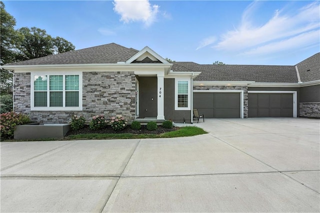 704 E 110th Ter, Kansas City, MO 64131 - view of front of house with stone siding, an attached garage, concrete driveway, and stucco siding