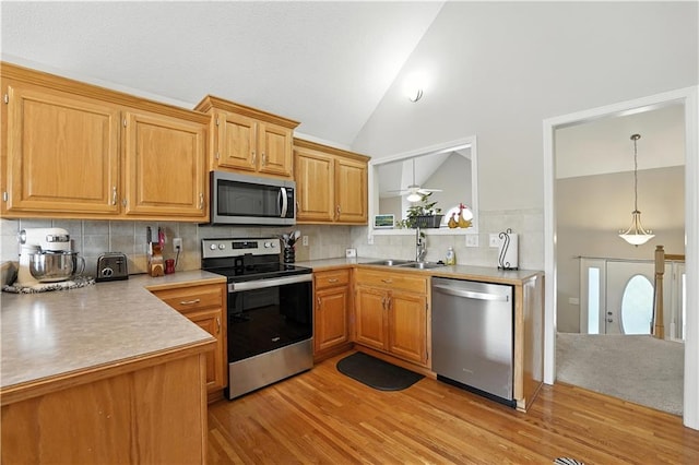 2353 SW Switchback Ct, Lees Summit, MO 64082 - kitchen featuring stainless steel appliances, light wood-style floors, light countertops, tasteful backsplash, and high vaulted ceiling