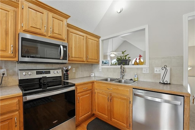 2353 SW Switchback Ct, Lees Summit, MO 64082 - kitchen with appliances with stainless steel finishes, vaulted ceiling, decorative backsplash, a ceiling fan, and light countertops