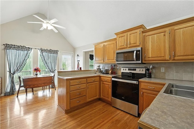 2353 SW Switchback Ct, Lees Summit, MO 64082 - kitchen featuring stainless steel appliances, a peninsula, ceiling fan, high vaulted ceiling, and light countertops