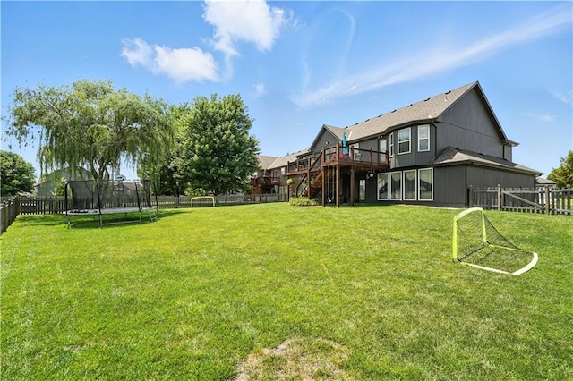 2353 SW Switchback Ct, Lees Summit, MO 64082 - fenced backyard with a trampoline, stairs, and a wooden deck