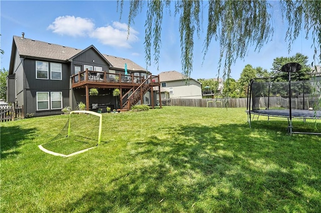 2353 SW Switchback Ct, Lees Summit, MO 64082 - fenced backyard with a trampoline, stairs, and a deck