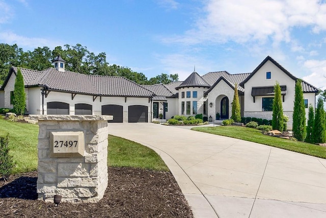 27497 W 108th St, Olathe, KS 66061 - view of front of home with driveway, an attached garage, stone siding, a front lawn, and a tile roof