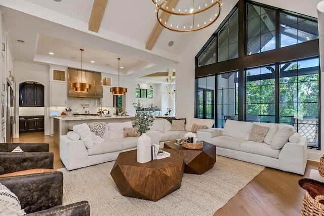 27497 W 108th St, Olathe, KS 66061 - living area featuring a chandelier, light wood-style flooring, recessed lighting, a towering ceiling, and a raised ceiling
