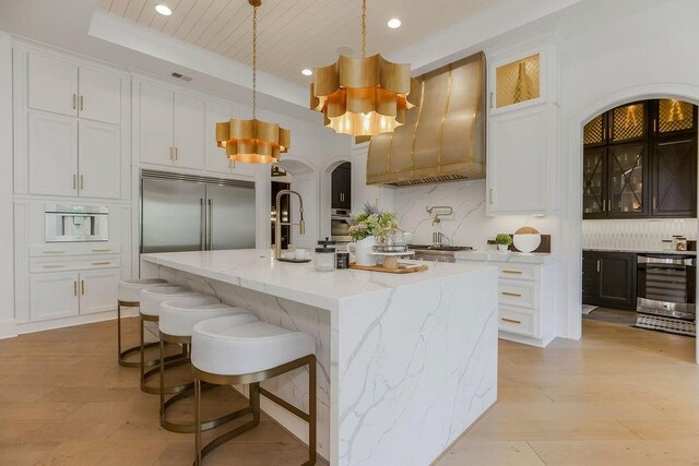 27497 W 108th St, Olathe, KS 66061 - kitchen with premium range hood, stainless steel appliances, beverage cooler, a chandelier, and recessed lighting