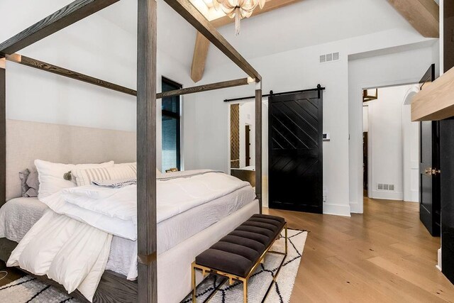 27497 W 108th St, Olathe, KS 66061 - bedroom featuring wood finished floors, a barn door, and beam ceiling