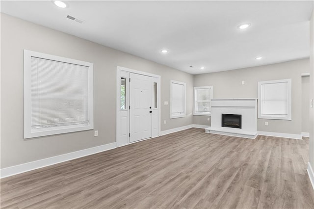 341 N 15th St, Kansas City, KS 66102 - unfurnished living room featuring light wood-style flooring, recessed lighting, and a fireplace with raised hearth
