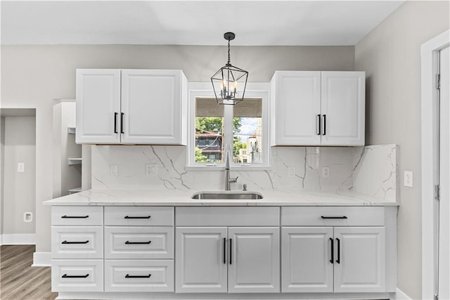 341 N 15th St, Kansas City, KS 66102 - kitchen with tasteful backsplash, light wood finished floors, white cabinetry, and hanging light fixtures