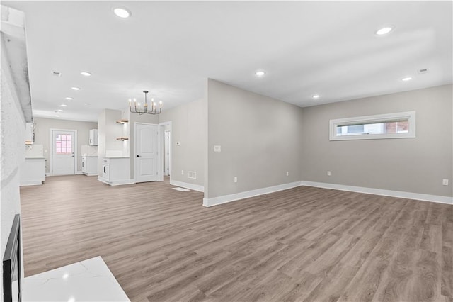341 N 15th St, Kansas City, KS 66102 - unfurnished living room featuring light wood-type flooring, a chandelier, recessed lighting, and a fireplace