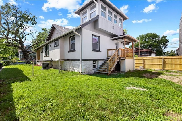 341 N 15th St, Kansas City, KS 66102 - back of property with a fenced backyard, stairs, and stucco siding
