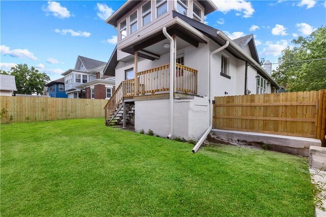 341 N 15th St, Kansas City, KS 66102 - rear view of property with a fenced backyard, stairway, and stucco siding