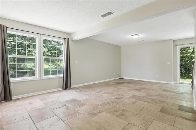 1501 SW Shelby Dr, Lees Summit, MO 64081 - unfurnished room with stone tile floors, a textured ceiling, and beam ceiling