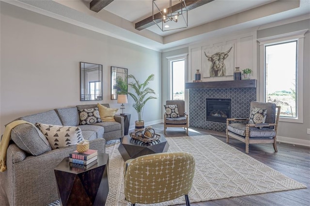 15389 W 173rd Ter, Olathe, KS 66062 - living room featuring wood finished floors, a chandelier, a tile fireplace, and beamed ceiling