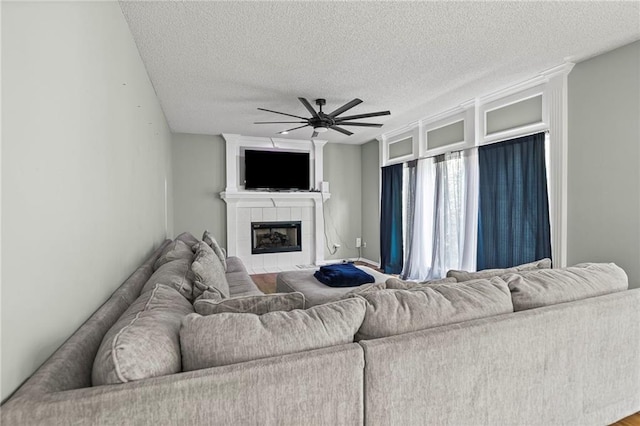14510 W 138th Ter, Olathe, KS 66062 - living area featuring ceiling fan, a textured ceiling, and a tiled fireplace