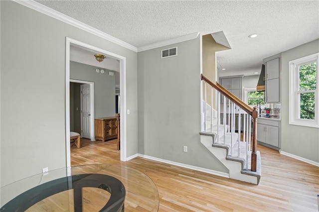 14510 W 138th Ter, Olathe, KS 66062 - stairway featuring wood finished floors, a textured ceiling, crown molding, and recessed lighting