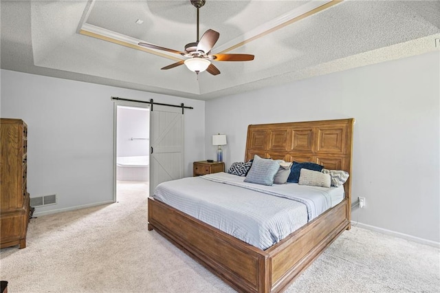 14510 W 138th Ter, Olathe, KS 66062 - carpeted bedroom with a barn door, a tray ceiling, ceiling fan, a textured ceiling, and ensuite bath