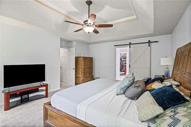 14510 W 138th Ter, Olathe, KS 66062 - bedroom featuring a tray ceiling, light carpet, a barn door, a ceiling fan, and a textured ceiling