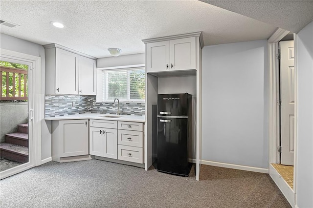 14510 W 138th Ter, Olathe, KS 66062 - kitchen with freestanding refrigerator, light carpet, light countertops, backsplash, and a textured ceiling