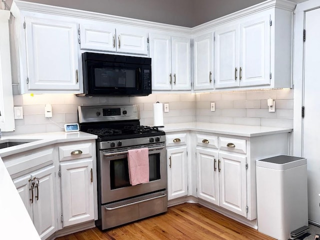11328 S Rene St, Olathe, KS 66215 - kitchen with gas stove, black microwave, white cabinetry, light countertops, and decorative backsplash
