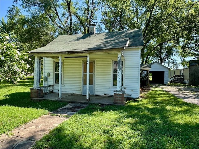 810 Center St, Pleasanton, KS 66075 - bungalow featuring a porch, a front lawn, a chimney, and a garage