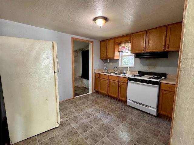 810 Center St, Pleasanton, KS 66075 - kitchen featuring white appliances, under cabinet range hood, a textured ceiling, light countertops, and brown cabinets