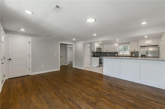 3414 Georgia Ave, Kansas City, KS 66104 - kitchen featuring stainless steel appliances, wood finished floors, white cabinetry, backsplash, and recessed lighting