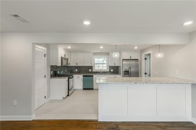 3414 Georgia Ave, Kansas City, KS 66104 - kitchen with stainless steel appliances, a peninsula, light stone countertops, tasteful backsplash, and recessed lighting