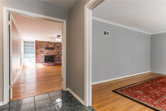 8224 Linden Dr, Prairie Village, KS 66208 - hall featuring crown molding, built in shelves, and dark tile patterned floors
