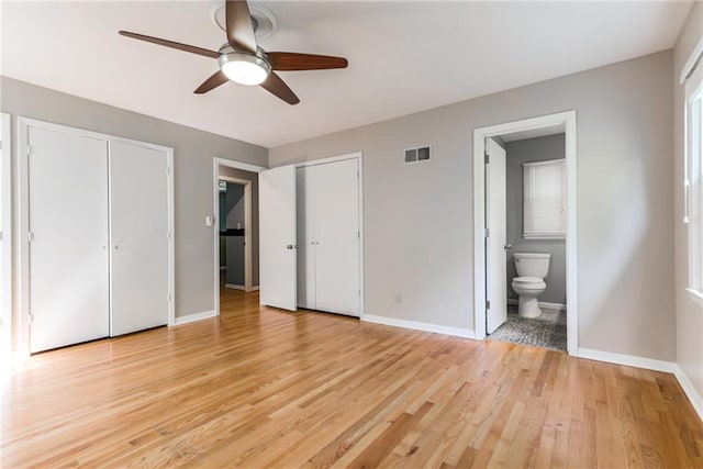 8224 Linden Dr, Prairie Village, KS 66208 - unfurnished bedroom with two closets, light wood finished floors, ensuite bath, and a ceiling fan