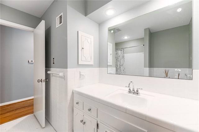 8224 Linden Dr, Prairie Village, KS 66208 - full bathroom featuring vanity, recessed lighting, wood finished floors, tile walls, and a shower with shower curtain