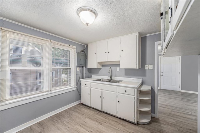 221 S High St, Independence, MO 64054 - kitchen featuring light wood-type flooring, white cabinetry, electric panel, light countertops, and a textured ceiling