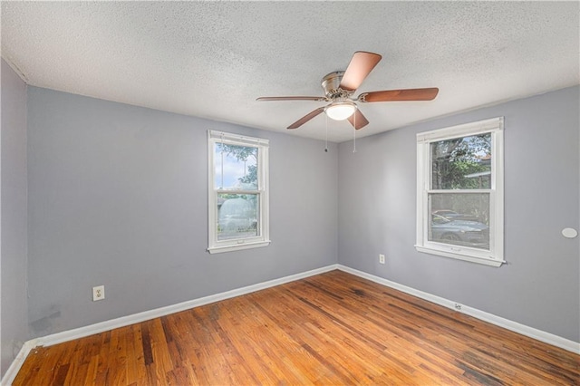 221 S High St, Independence, MO 64054 - empty room featuring healthy amount of natural light, a textured ceiling, wood finished floors, and ceiling fan