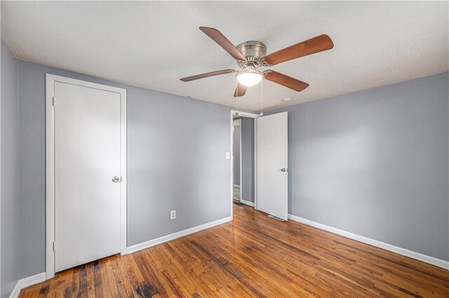 221 S High St, Independence, MO 64054 - unfurnished bedroom with wood finished floors and a ceiling fan