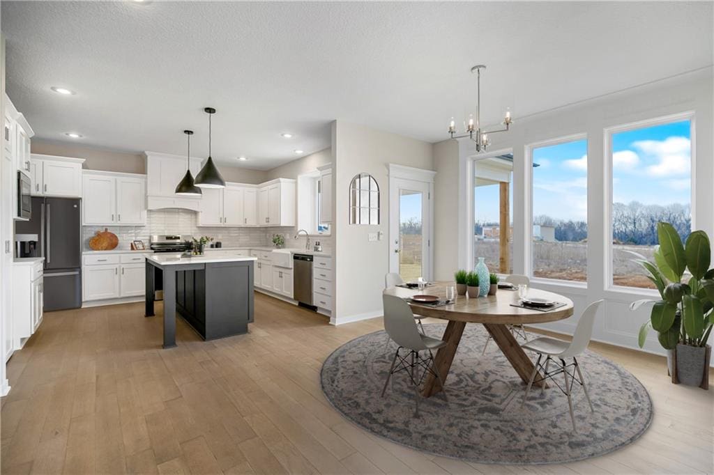 9292 Zarda Dr, Lenexa, KS 66227 - kitchen with stainless steel appliances, a kitchen island, tasteful backsplash, a chandelier, and light countertops
